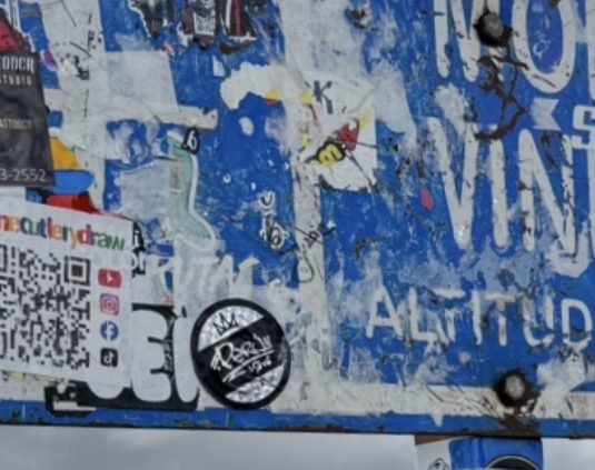 Peru Street sticker detail on a weathered street sign